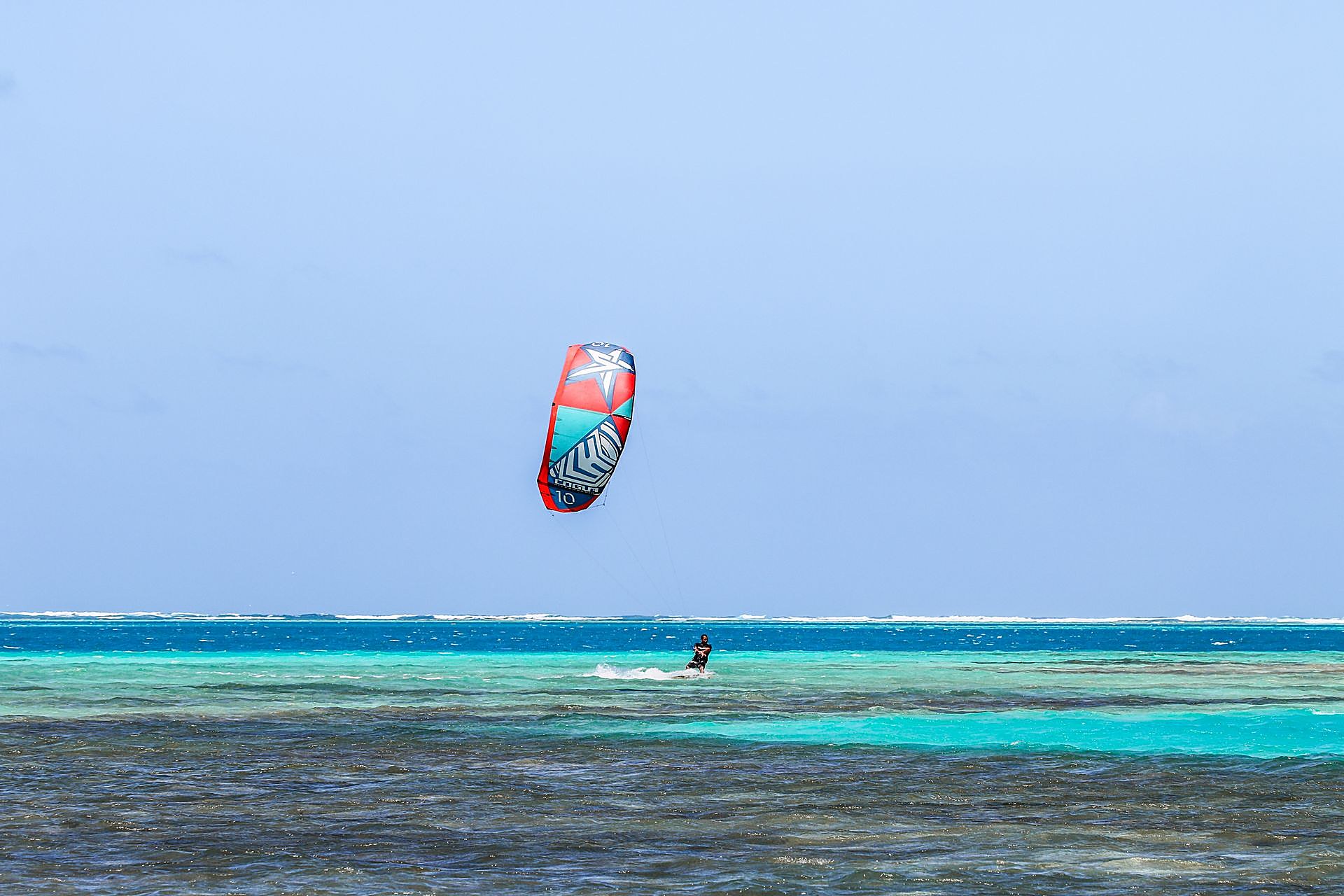 Kitesurfer gliding over the turquoise lagoon at Michamvi, Zanzibar