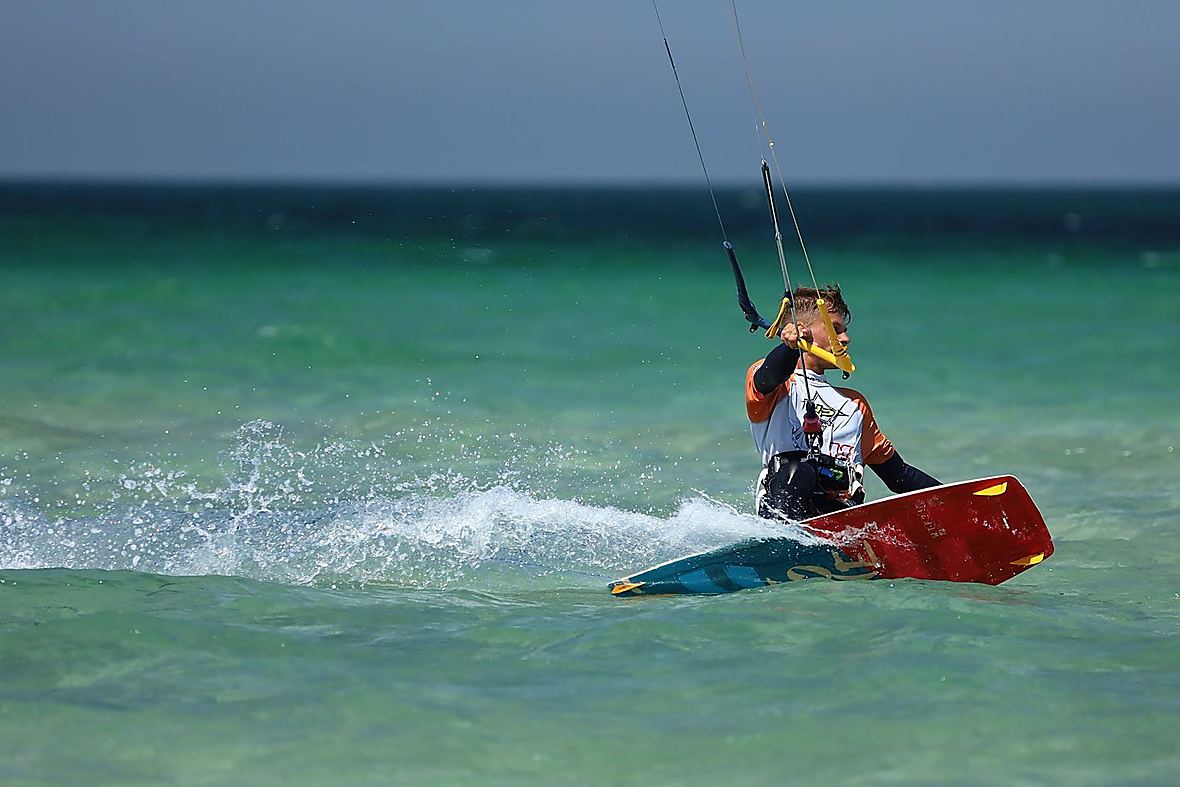 Kitesurfer riding across turquoise water in Zanzibar