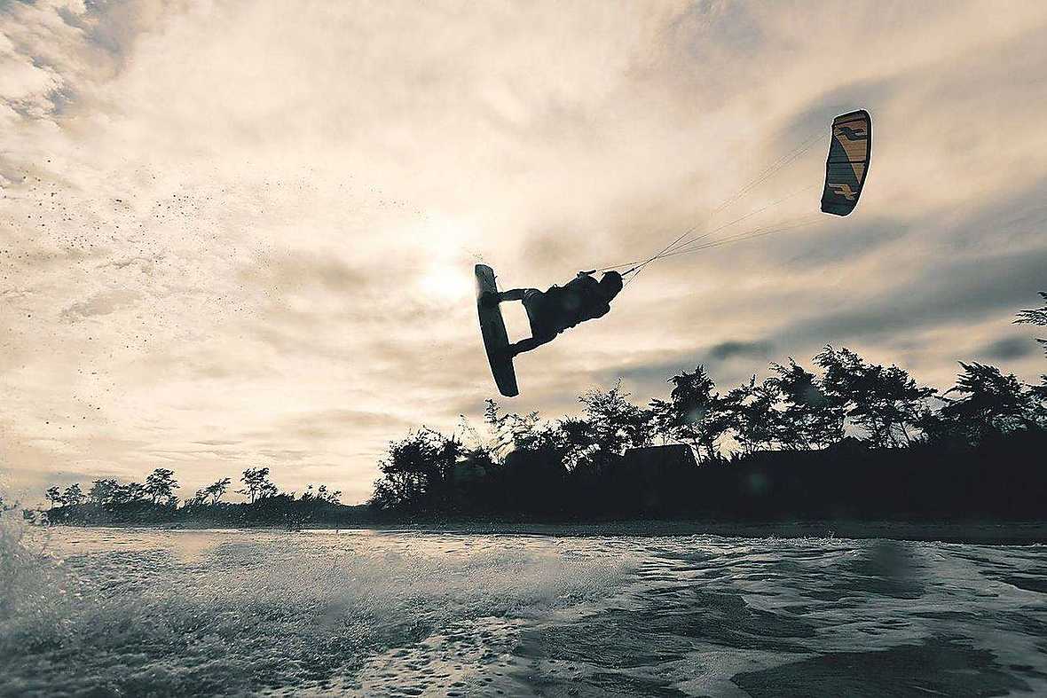 Kitesurf riders at sunset on a Zanzibar beach